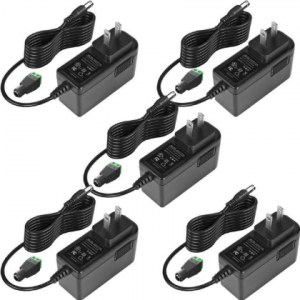 Five identical black power adapters with attached cords and plugs are arranged in a pattern on a white background. Each adapter has a standard two-prong plug and a small green connector at the end of the cable.